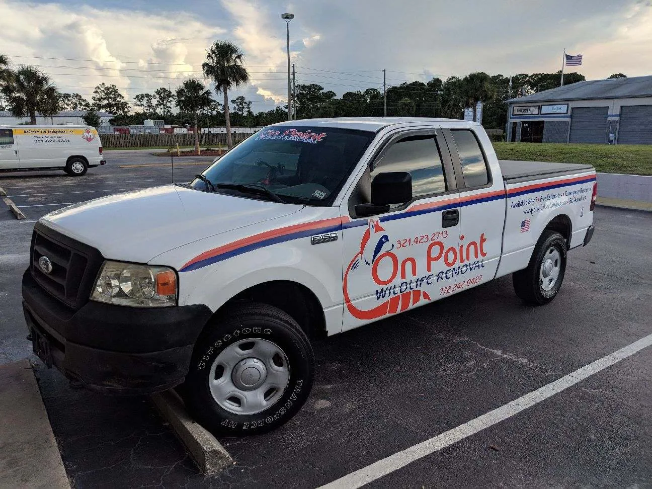 On Point Wildlife Truck in parking lot with palm trees in the background.